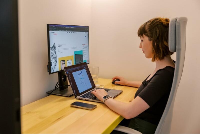A Wolfpack Digital designer working at a desktop monitor showing the Wolfpack Digital projects page